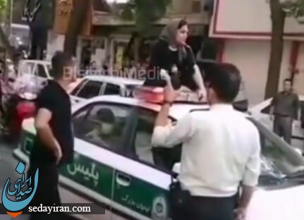 ماجرای نشستن یک زن روی ماشین پلیس / شوهرم را آزاد کنید!